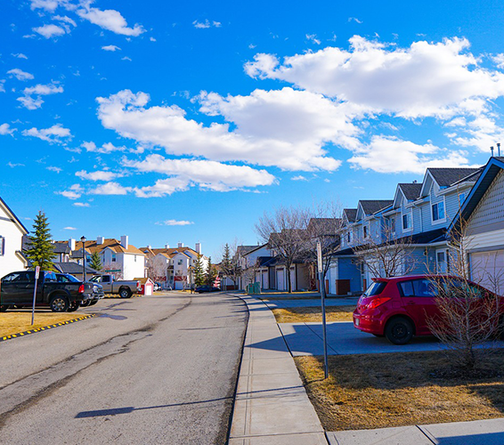 quiet residential street with a row of modern townhouses